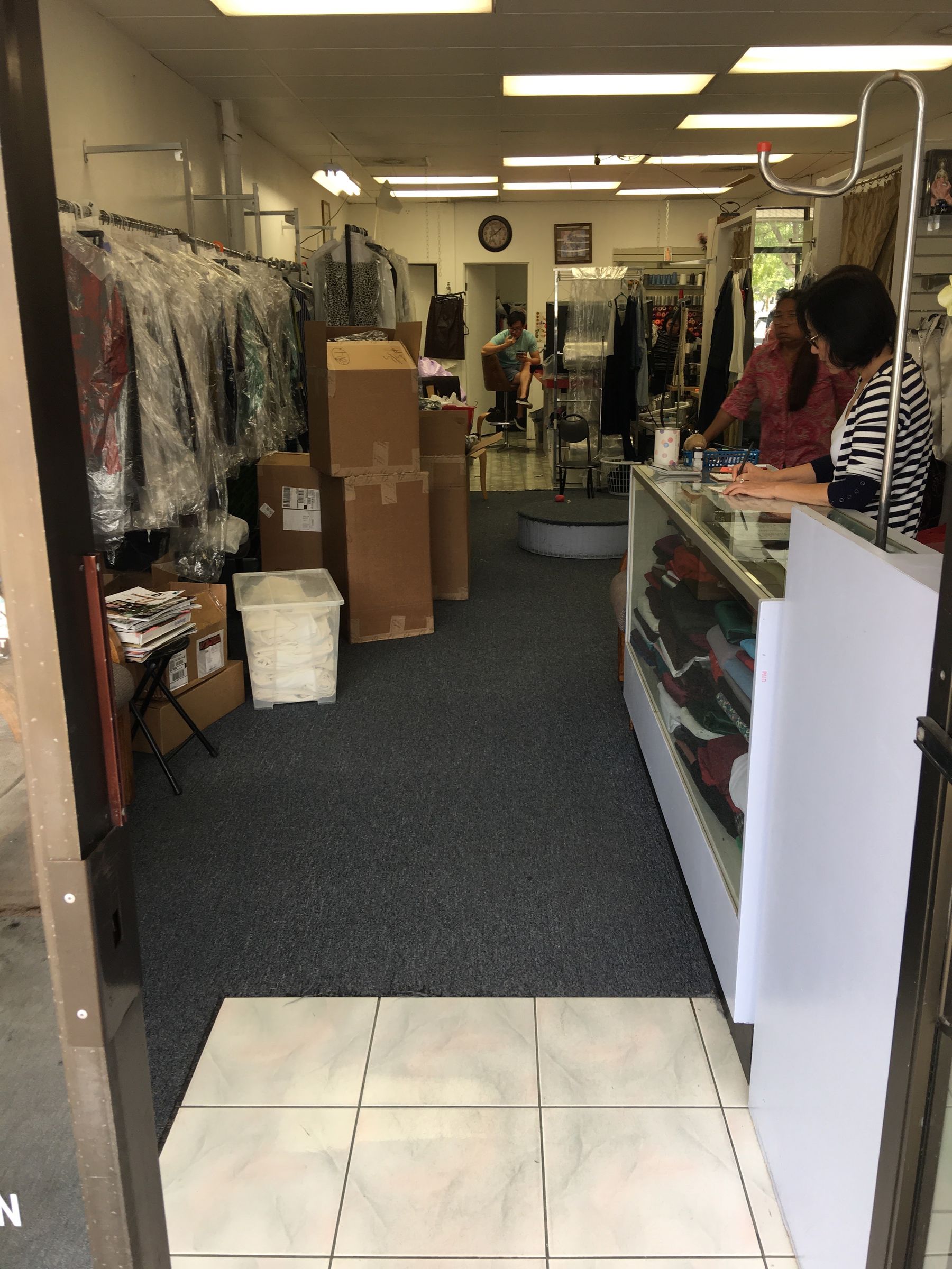 Shop interior with the counter and racks of finished garments